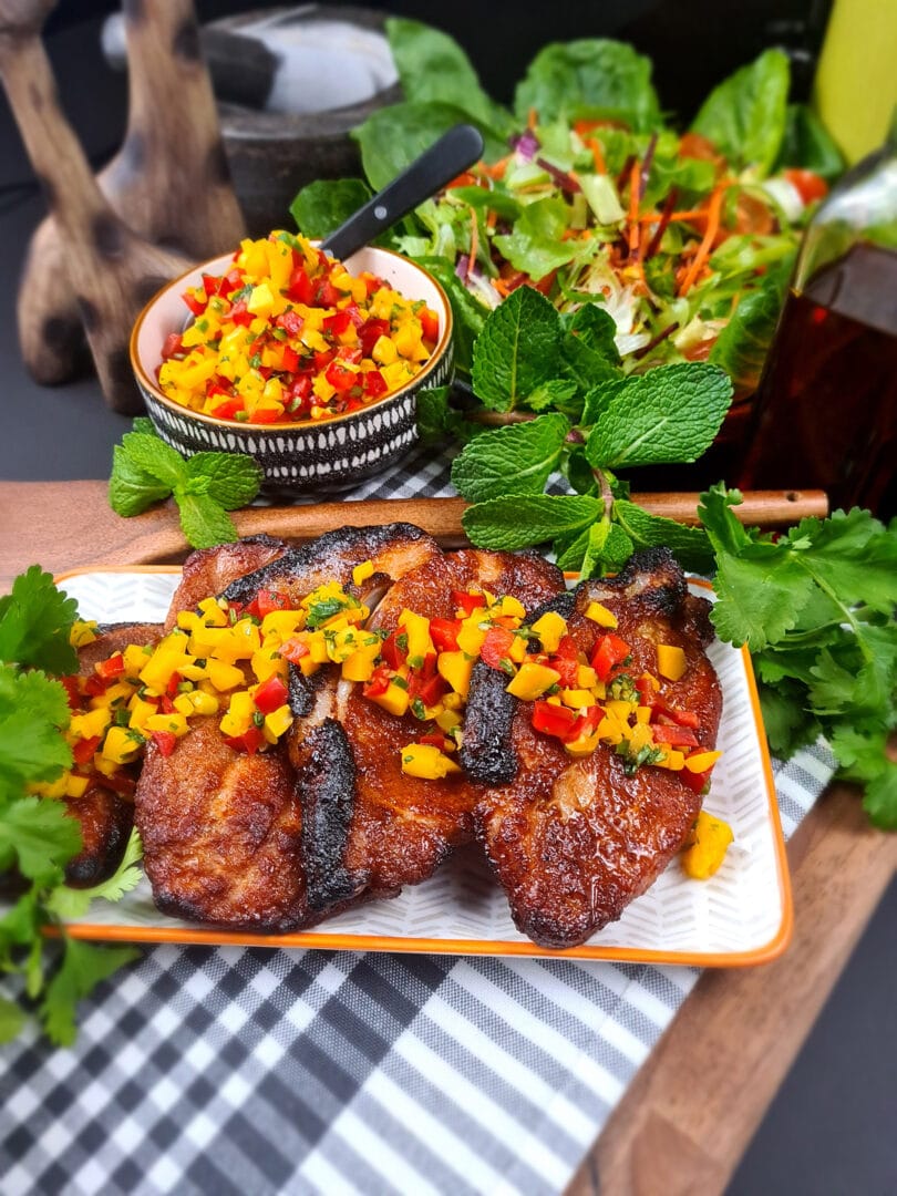 Sticky BBQ glazed pork topped with mango salsa and garnished with salad leaves