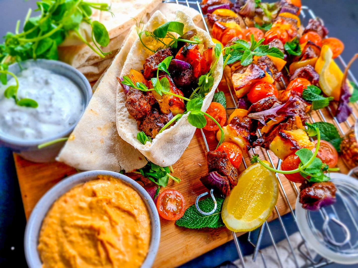 Minted lamb and halloumi kebabs laid out and served with pitta bread